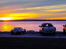 Sunset over water behind a corvette