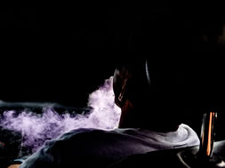 Guy blowing out purple smoke