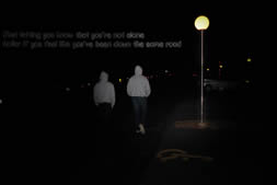 Two guys walking under street light with words: Just letting you know that youre not alone Holler if youve been down the same road